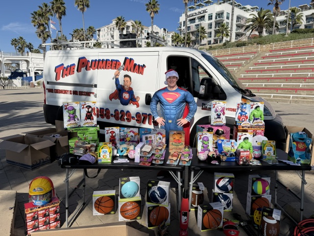 The Plumber Man van and table full of toys for community giveaway