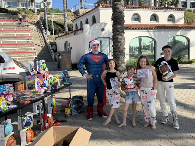 Kids lining up to pick toys from The Plumber Man community event